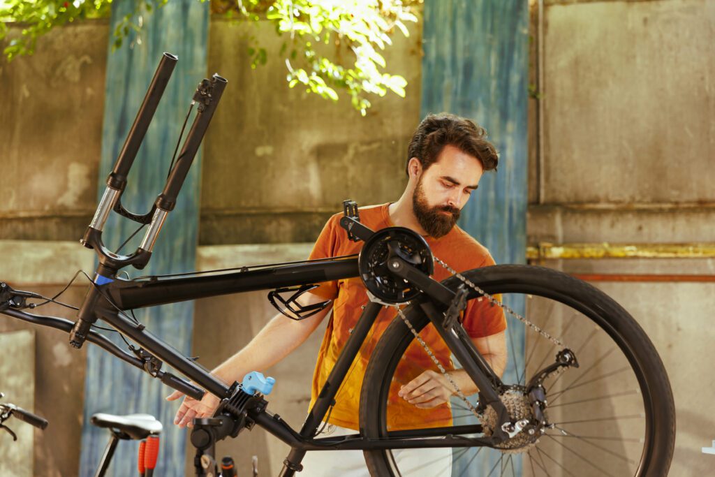 Vitesili Bisiklet Nasıl Kullanılmalı? 3 Altın Kural Sürüş Kuralı athletic male repairs modern bicycle